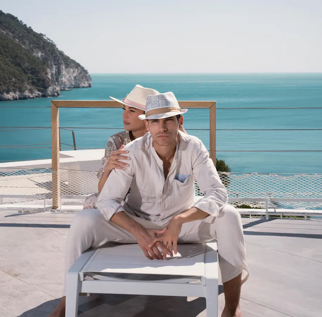 Couple wearing Marone hats on the sea-view terrace