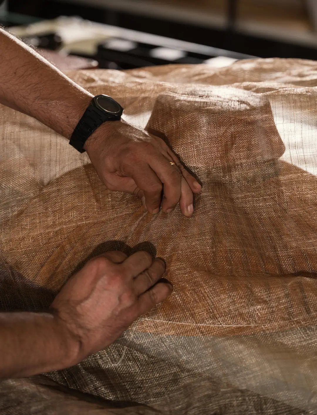 Stroh wird von Hand auf der Holzform bearbeitet