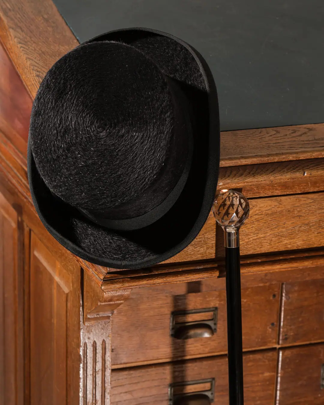 Schwarzer Filzhut auf dem Archivschrank